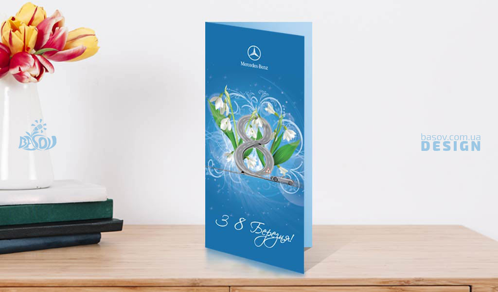 Вітальна листівка з 8 березня від компанії Mercedes-Benz стоїть на столі біля тюльпанів